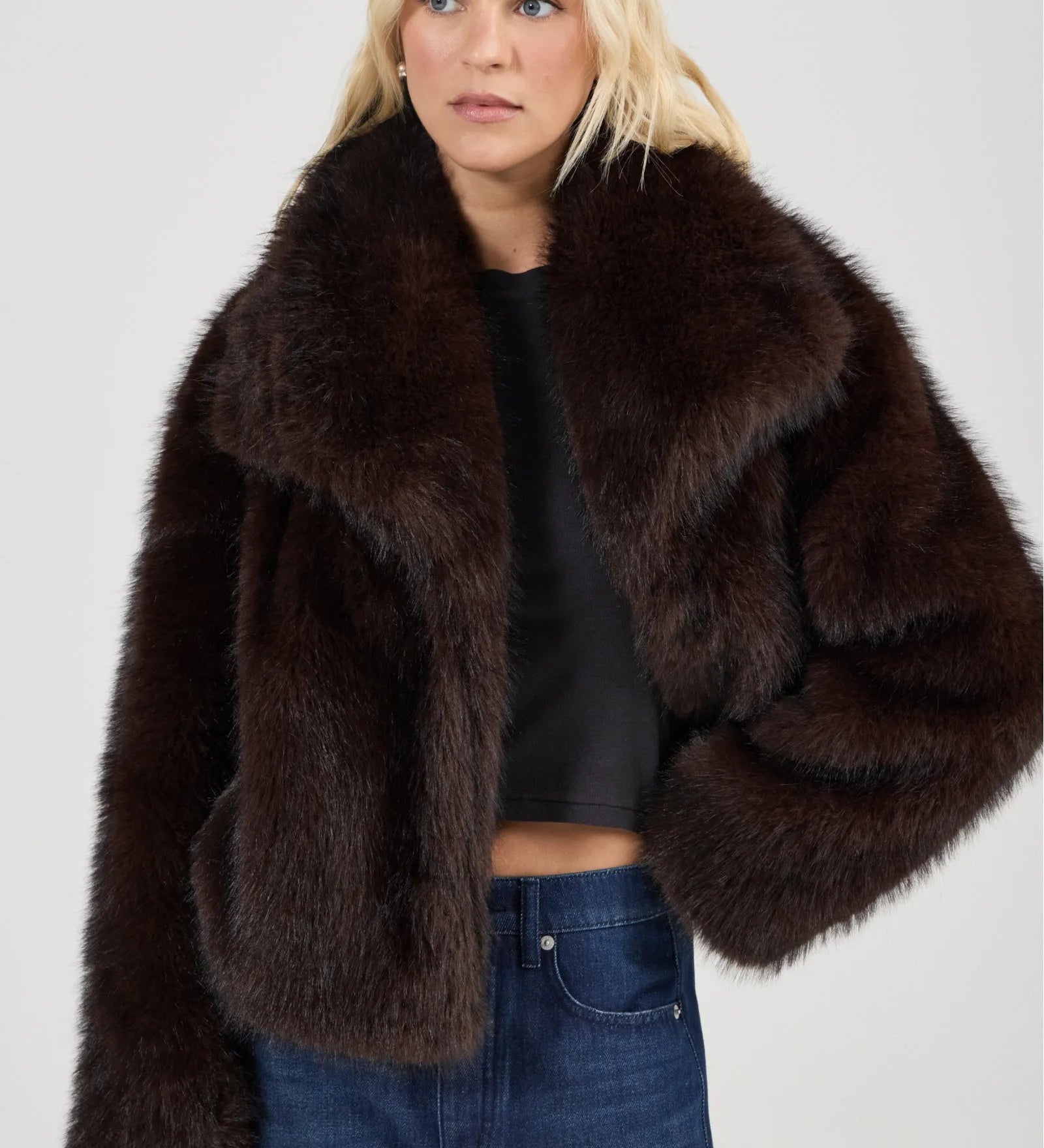 Woman wearing a brown fur coat on a plain background
