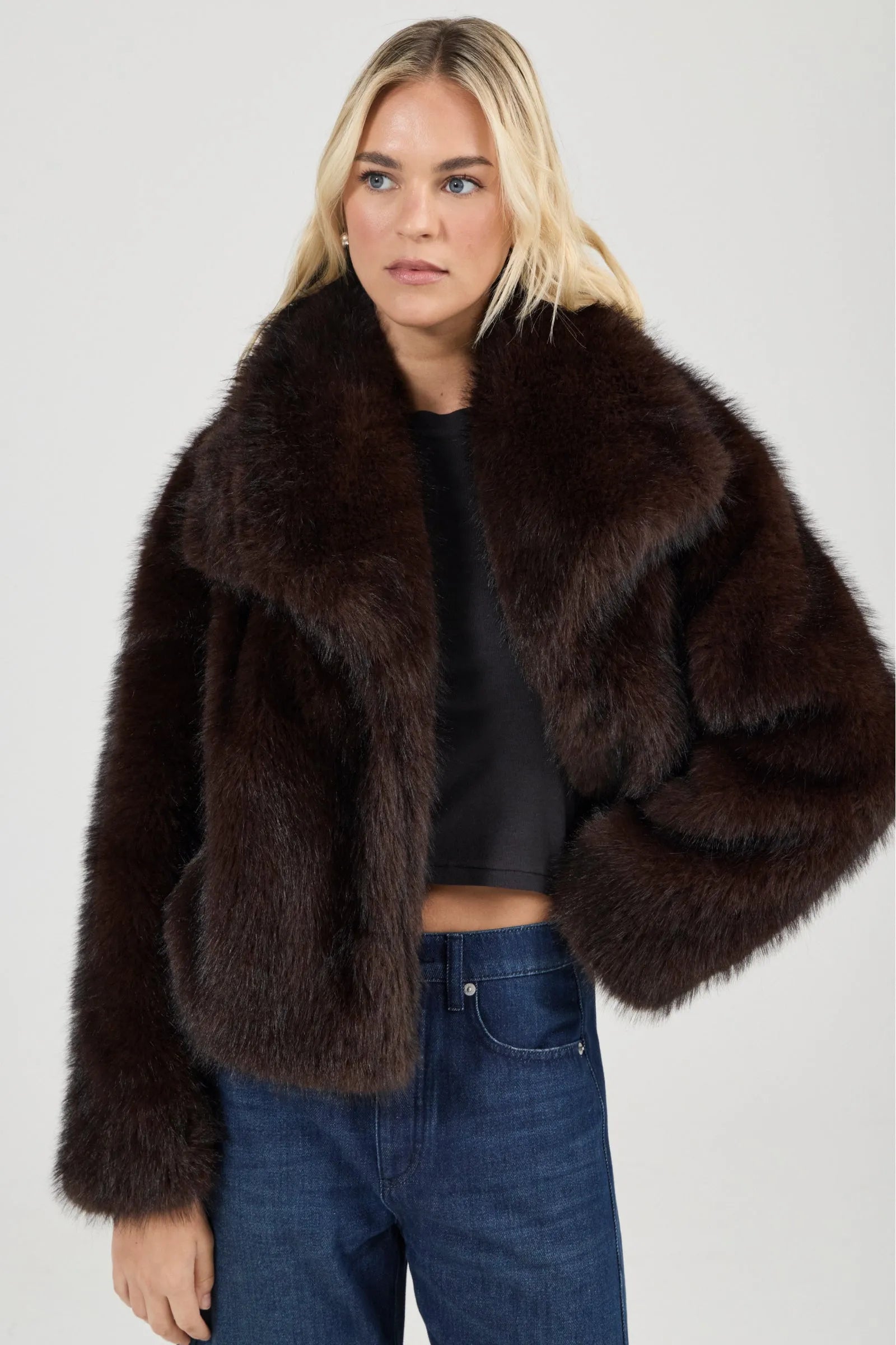 Woman wearing a brown fur coat on a plain background