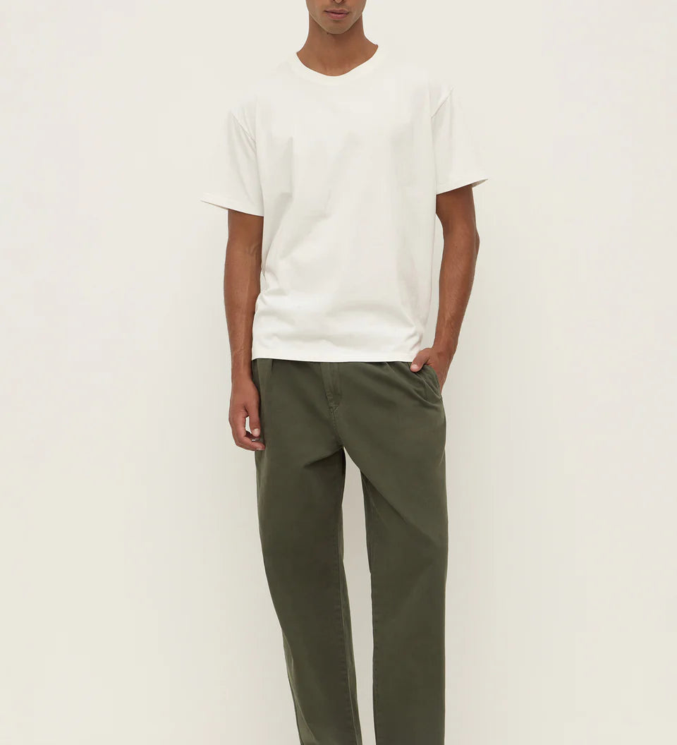 Man wearing a white t-shirt and green pants on a white background