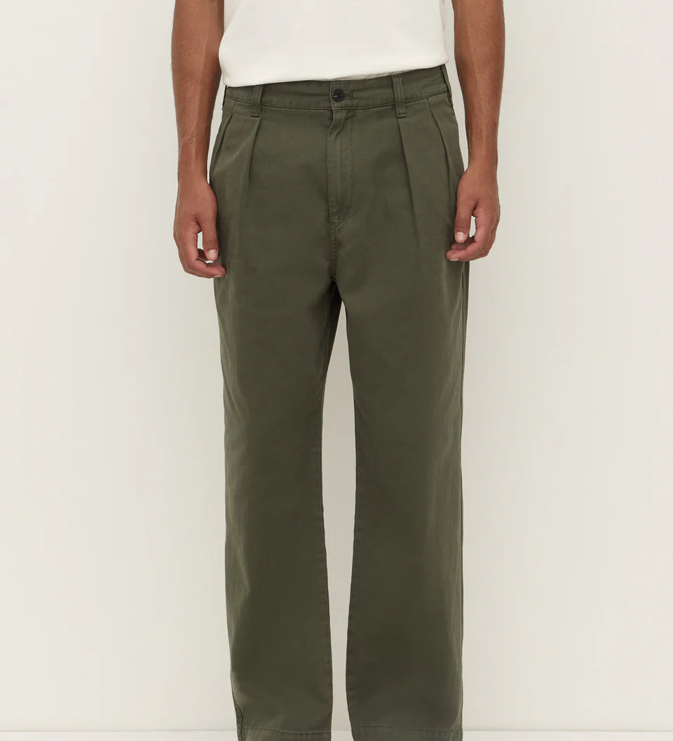 Person wearing olive green pants and a white shirt on a plain background