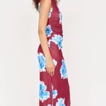 Woman wearing a burgundy dress with blue floral pattern on a white background