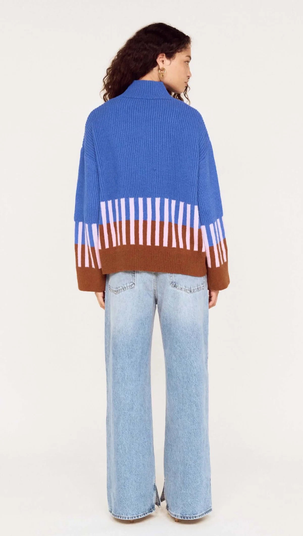Person wearing a colorful sweater with a white background