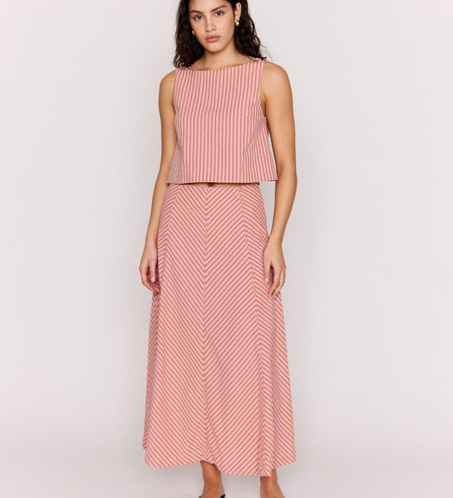 Woman wearing a pink and white striped sleeveless top and skirt on a white background