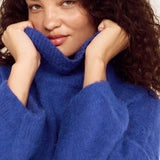 Woman wearing a blue sweater against a white background