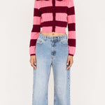 Person wearing a striped sweater and jeans on a white background