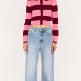 Person wearing a striped sweater and jeans on a white background