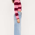 Person wearing a striped sweater and jeans on a white background