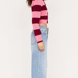 Person wearing a striped sweater and jeans on a white background