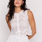 Woman wearing a white lace dress against a plain background
