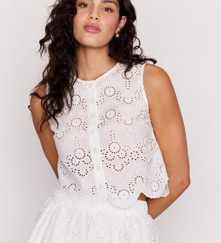 Woman wearing a white lace dress against a plain background