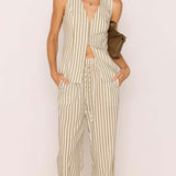 Woman wearing a striped jumpsuit against a plain background