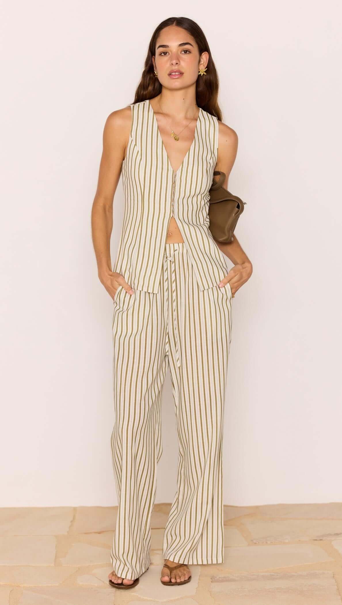 Woman wearing a striped jumpsuit against a plain background