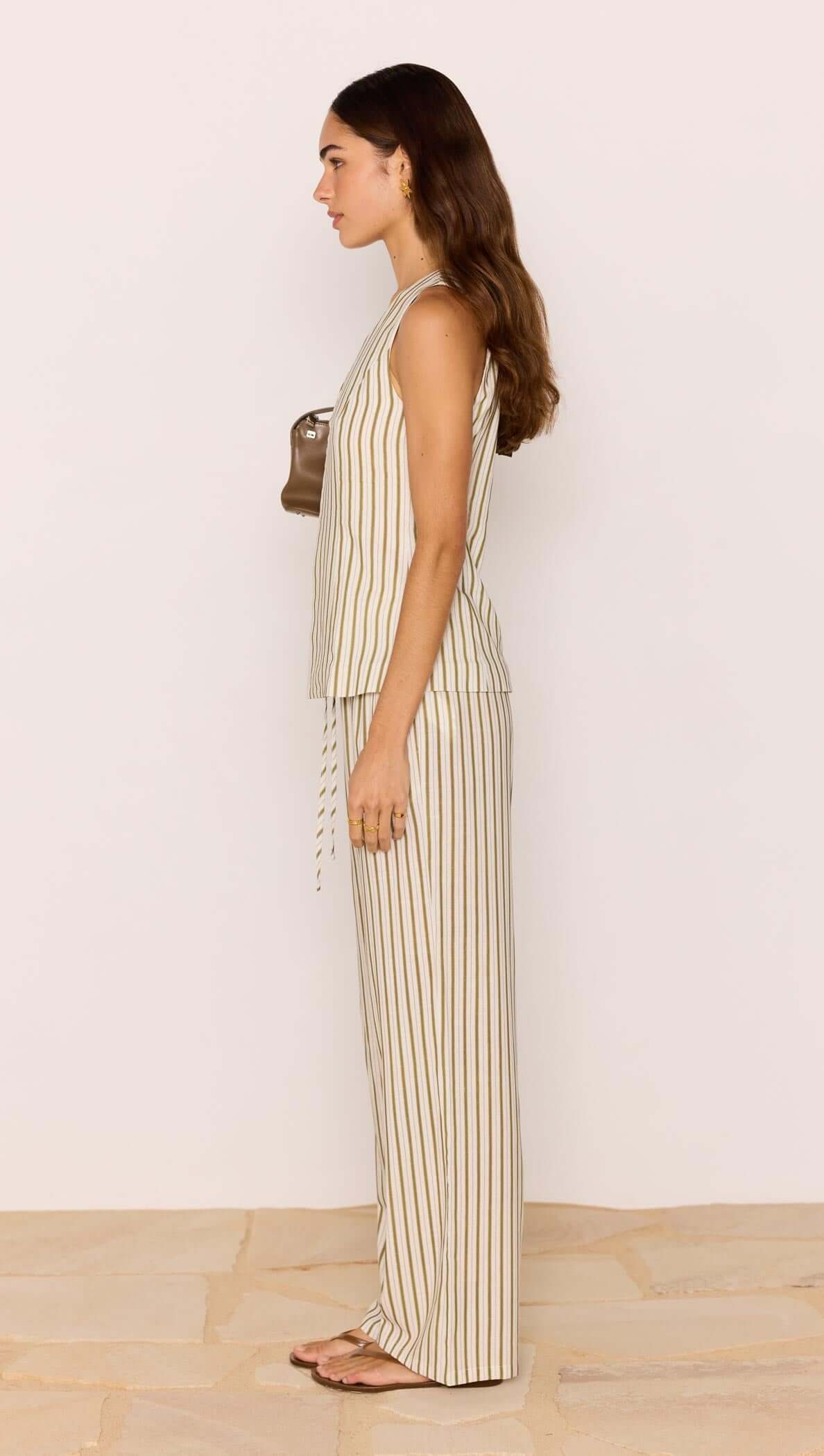 Woman wearing a striped jumpsuit against a plain background