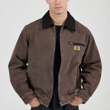 Man wearing a brown jacket with a visible brand logo on a white background