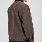 Man wearing a brown jacket on a plain background