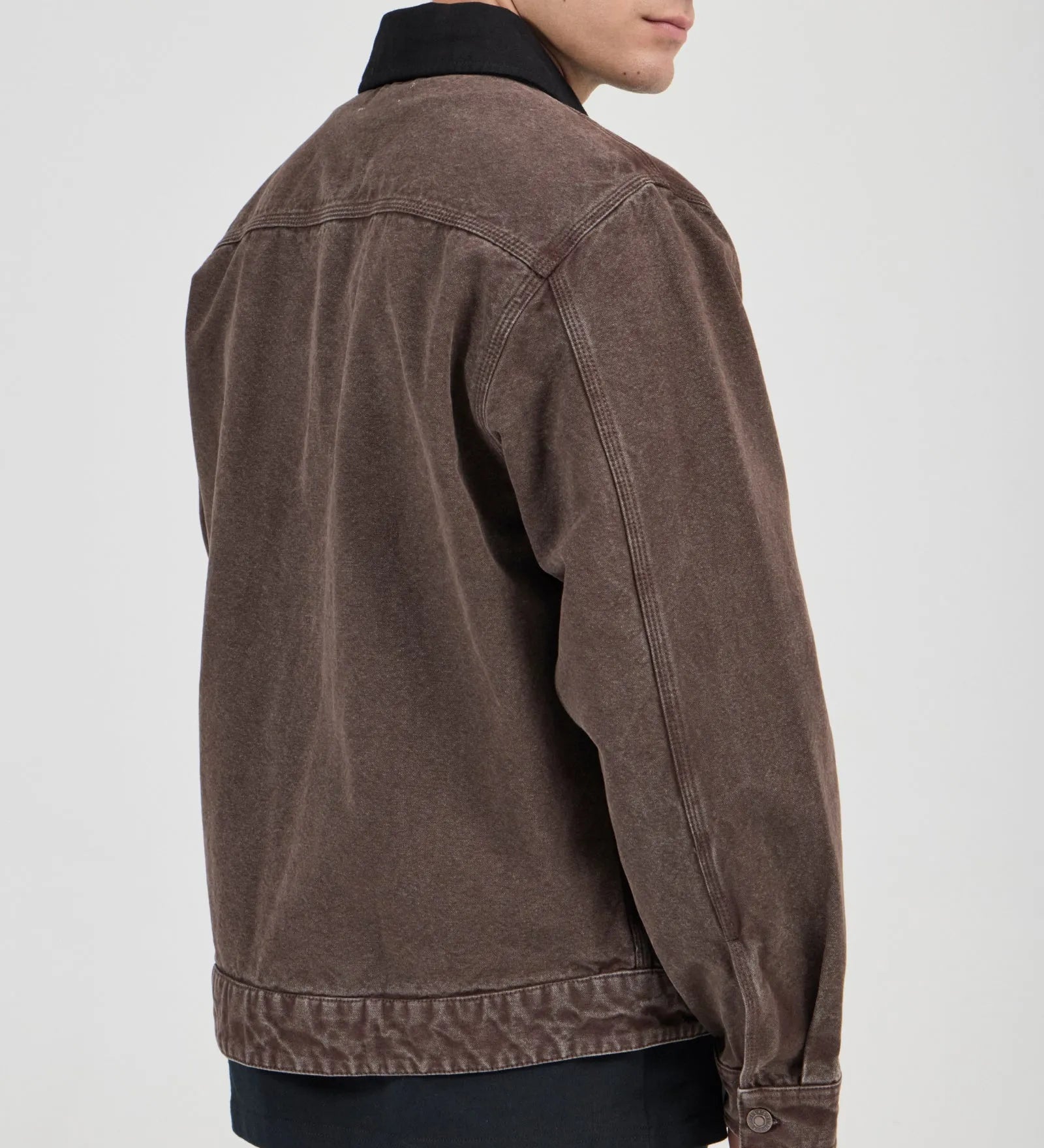 Man wearing a brown jacket on a plain background