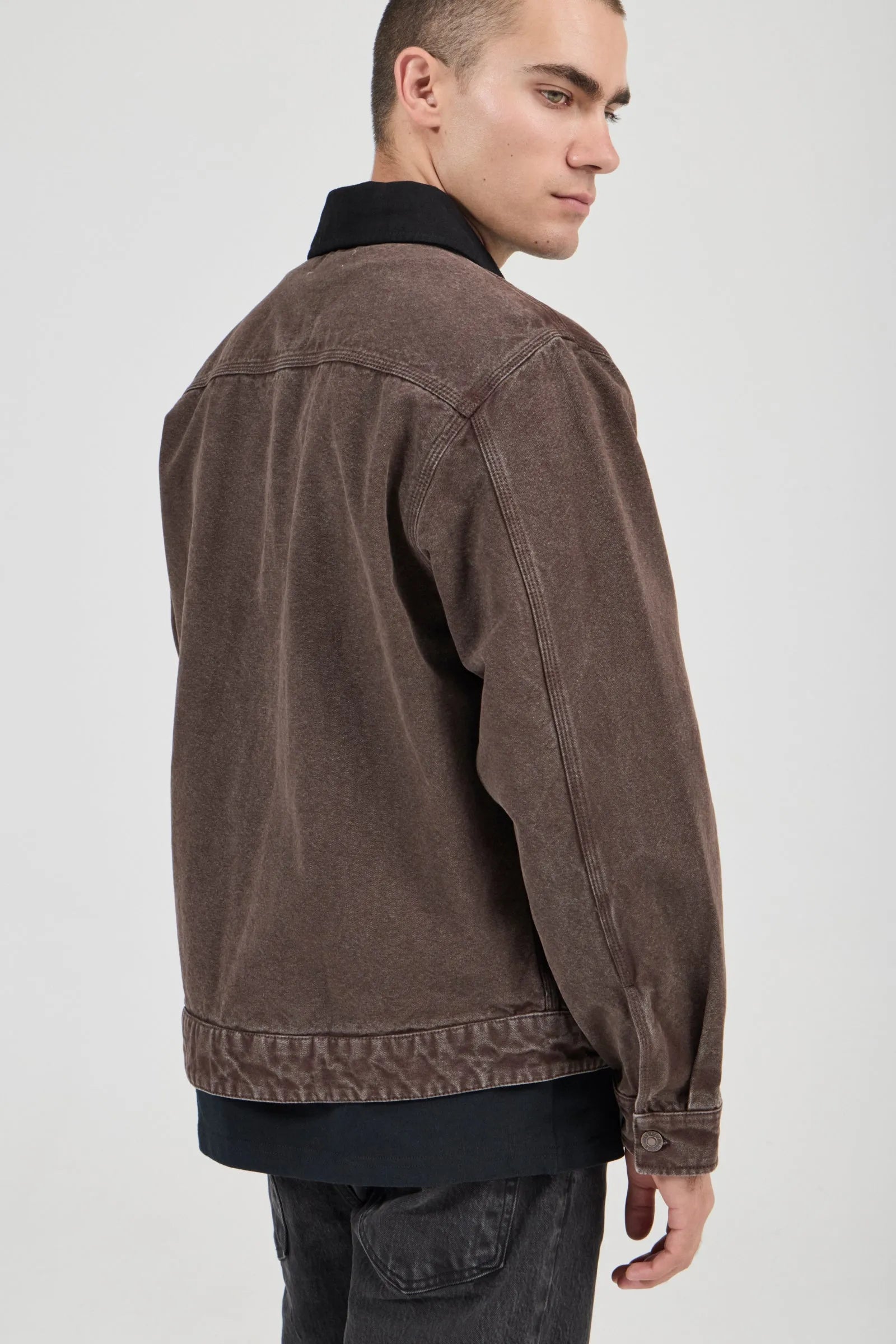 Man wearing a brown jacket on a plain background