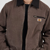 Brown jacket with a logo patch on a white background