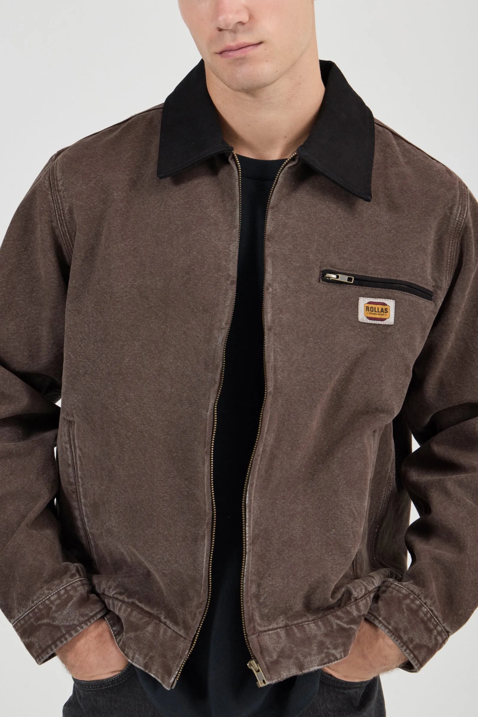 Brown jacket with a logo patch on a white background