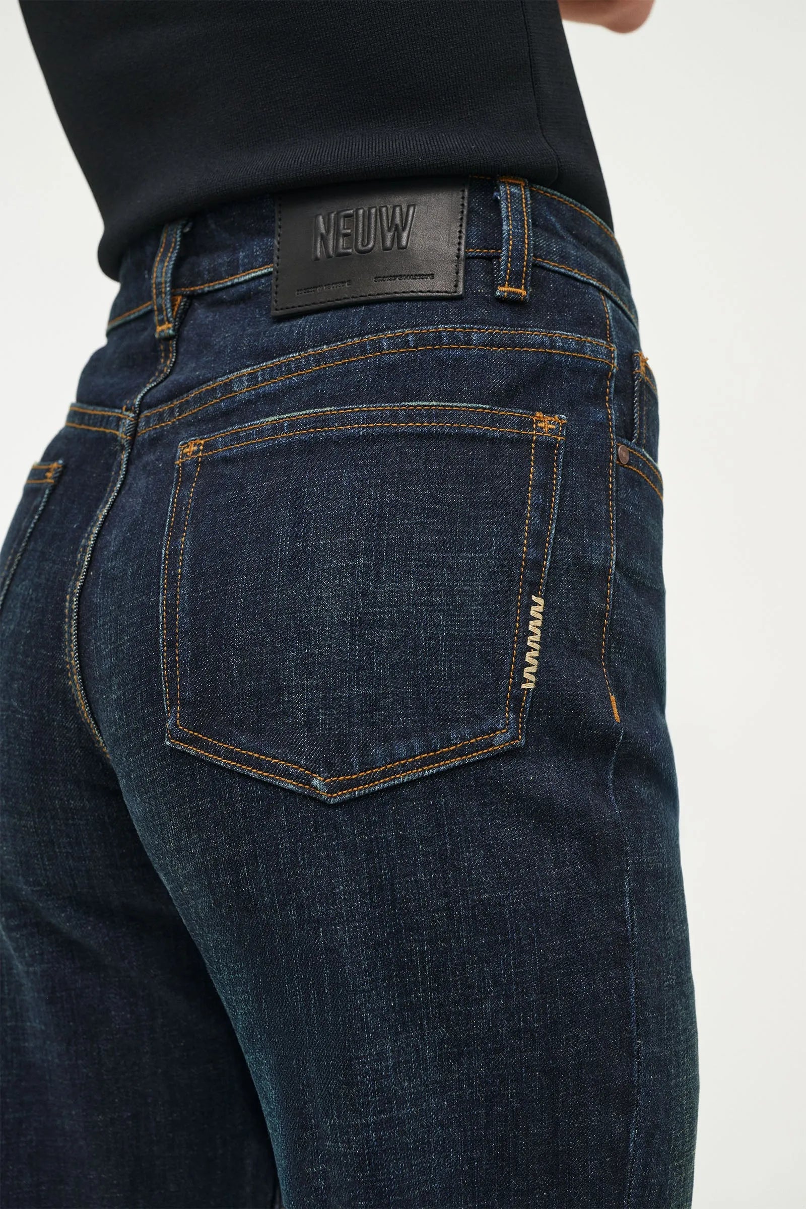 Dark blue jeans with a visible brand label on a white background