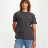 Person wearing a dark gray t-shirt with a small red logo on a white background