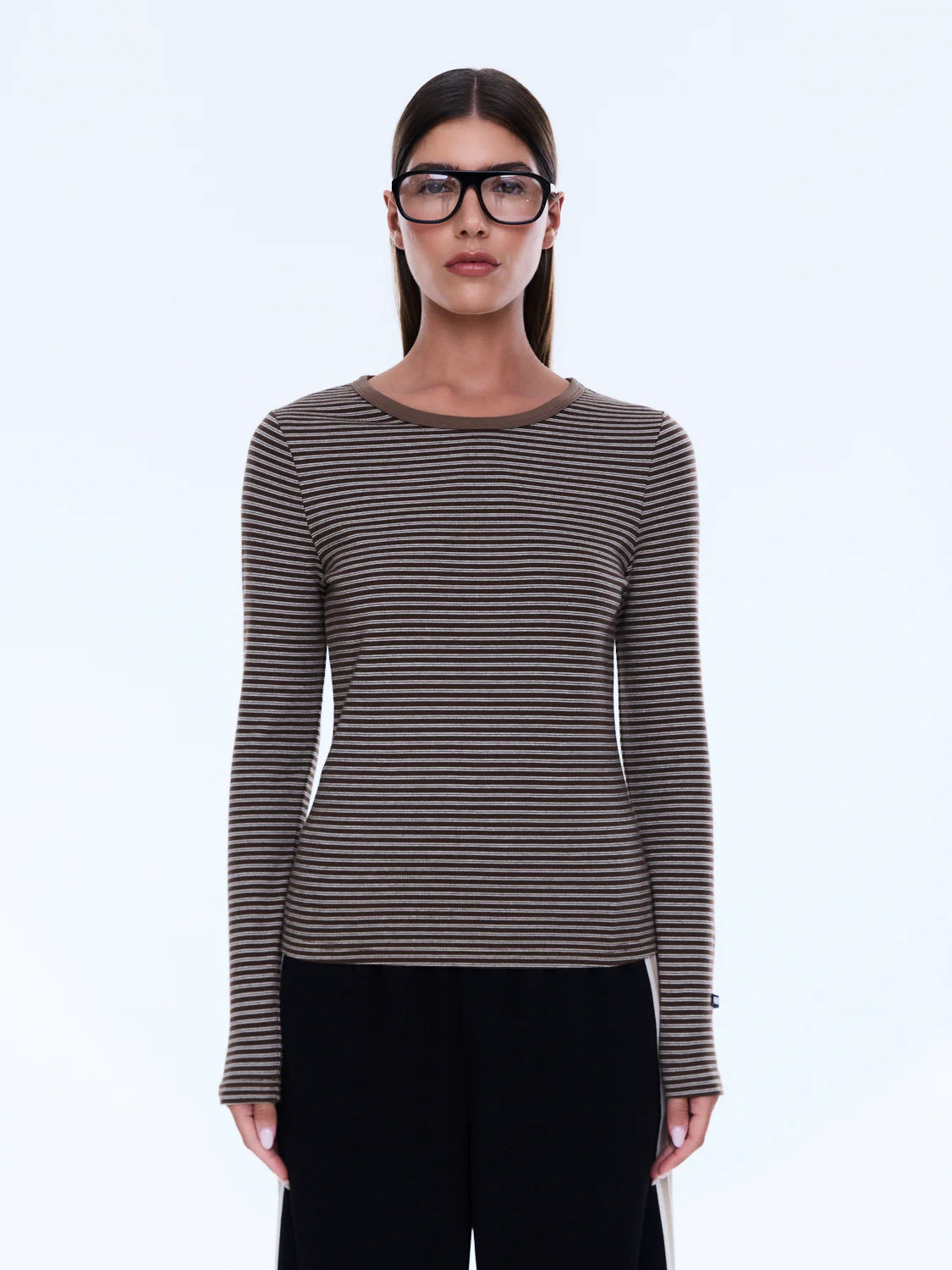 Woman wearing a striped long-sleeve shirt and glasses on a white background