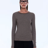 Woman wearing a striped long-sleeve shirt and glasses on a white background
