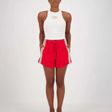 A person standing wearing red and white shorts with a drawstring waist and white top.