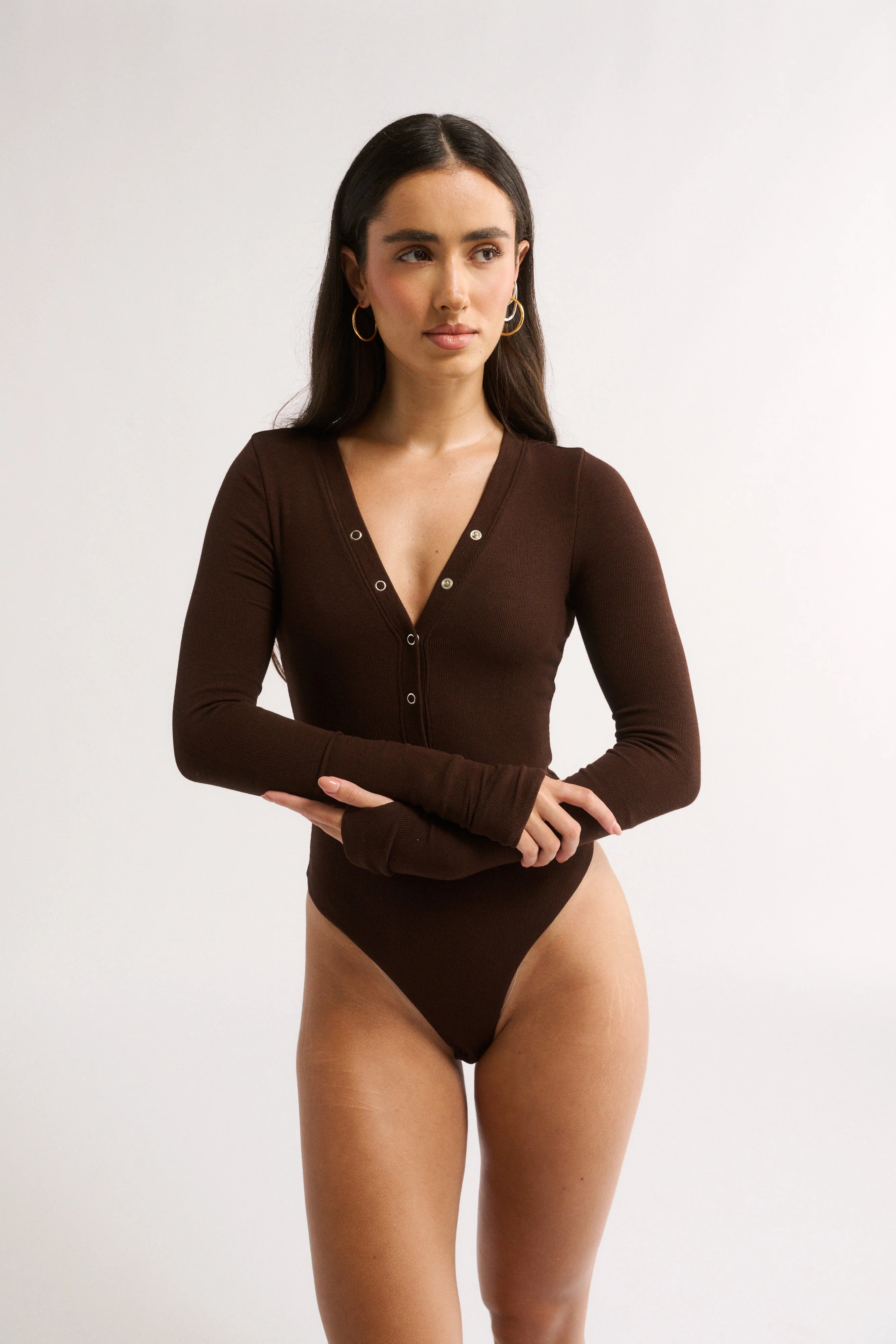 Woman wearing a brown bodysuit on a white background