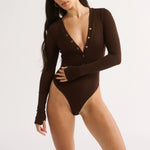 Woman wearing a brown bodysuit on a white background