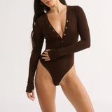 Woman wearing a brown bodysuit on a white background