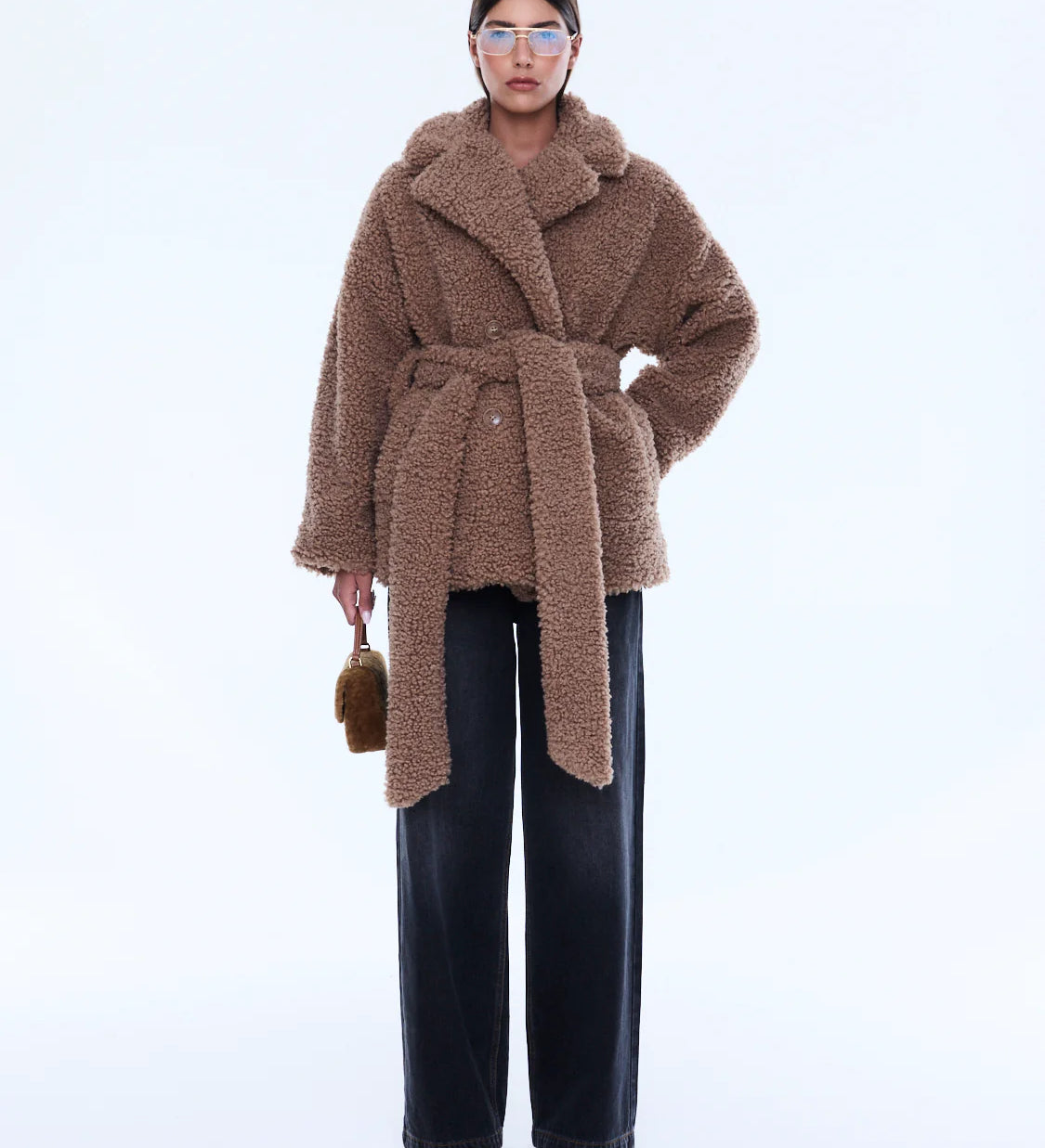 Woman wearing a brown teddy coat on a white background