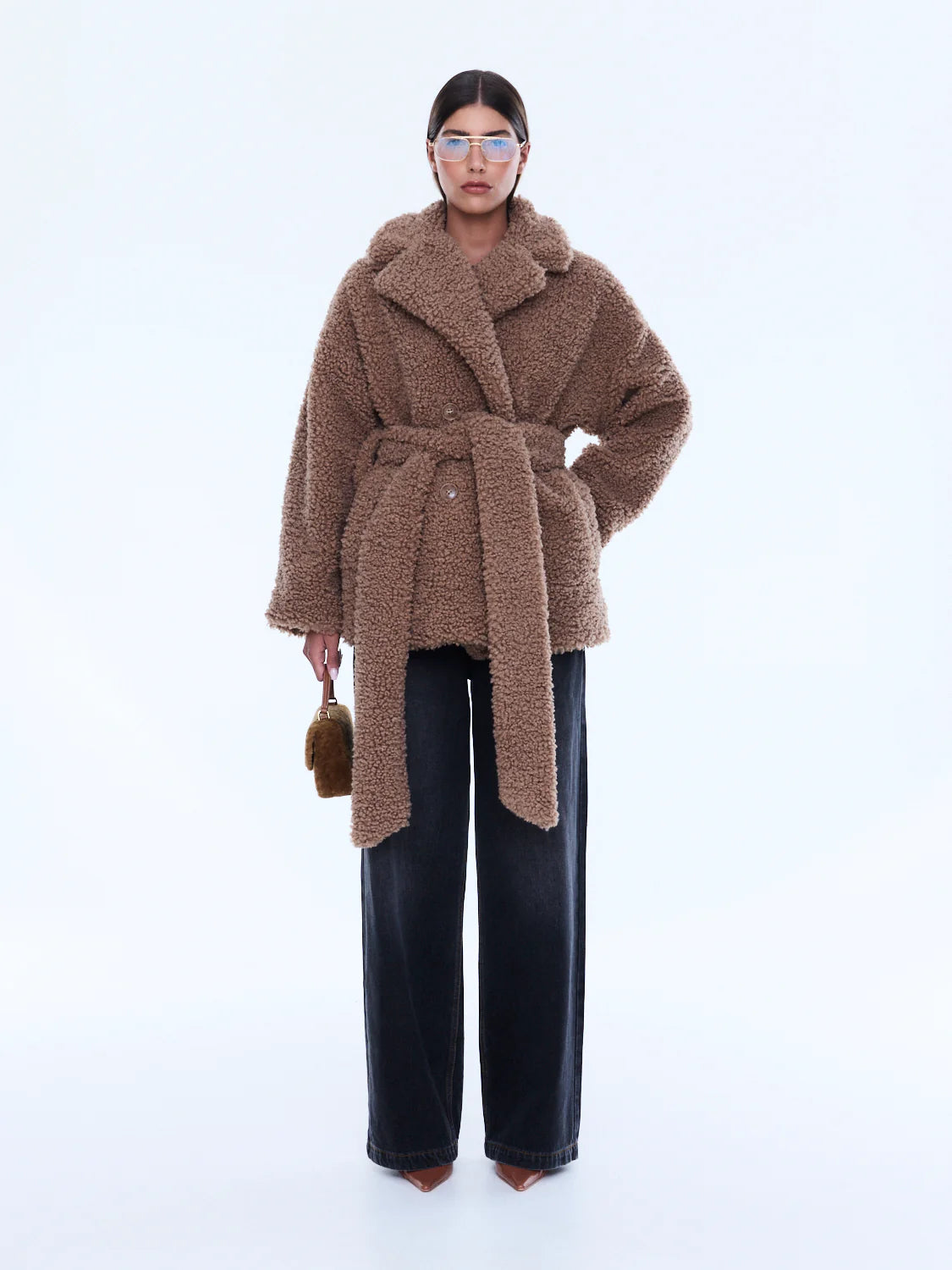 Woman wearing a brown teddy coat on a white background