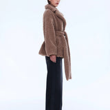 Woman wearing a brown teddy coat on a white background