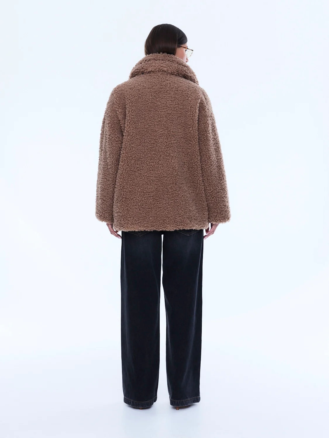 Person wearing a brown fluffy coat on a white background