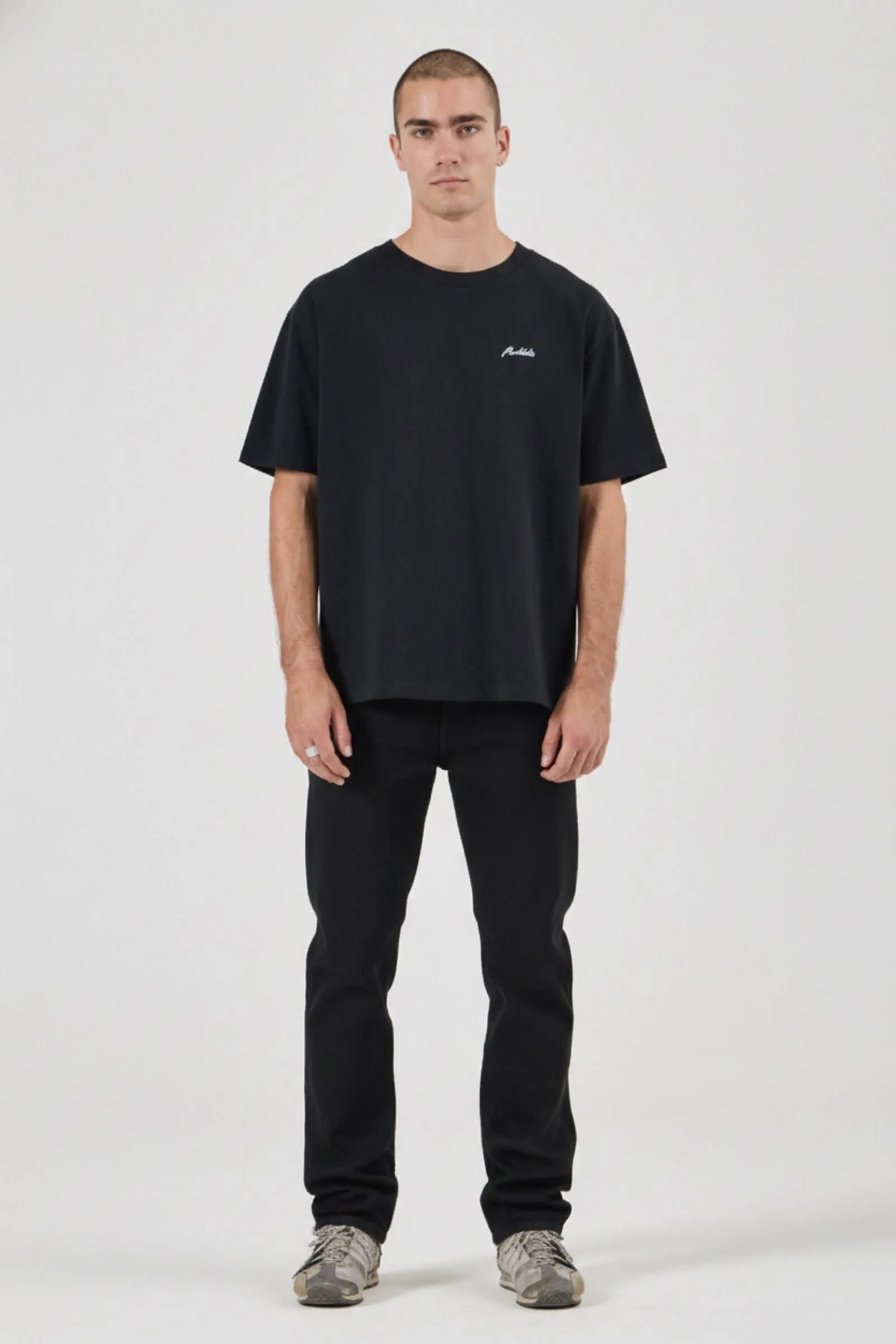 Man wearing a black t-shirt and pants on a white background