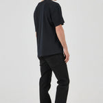 Person wearing a black t-shirt and black pants on a white background