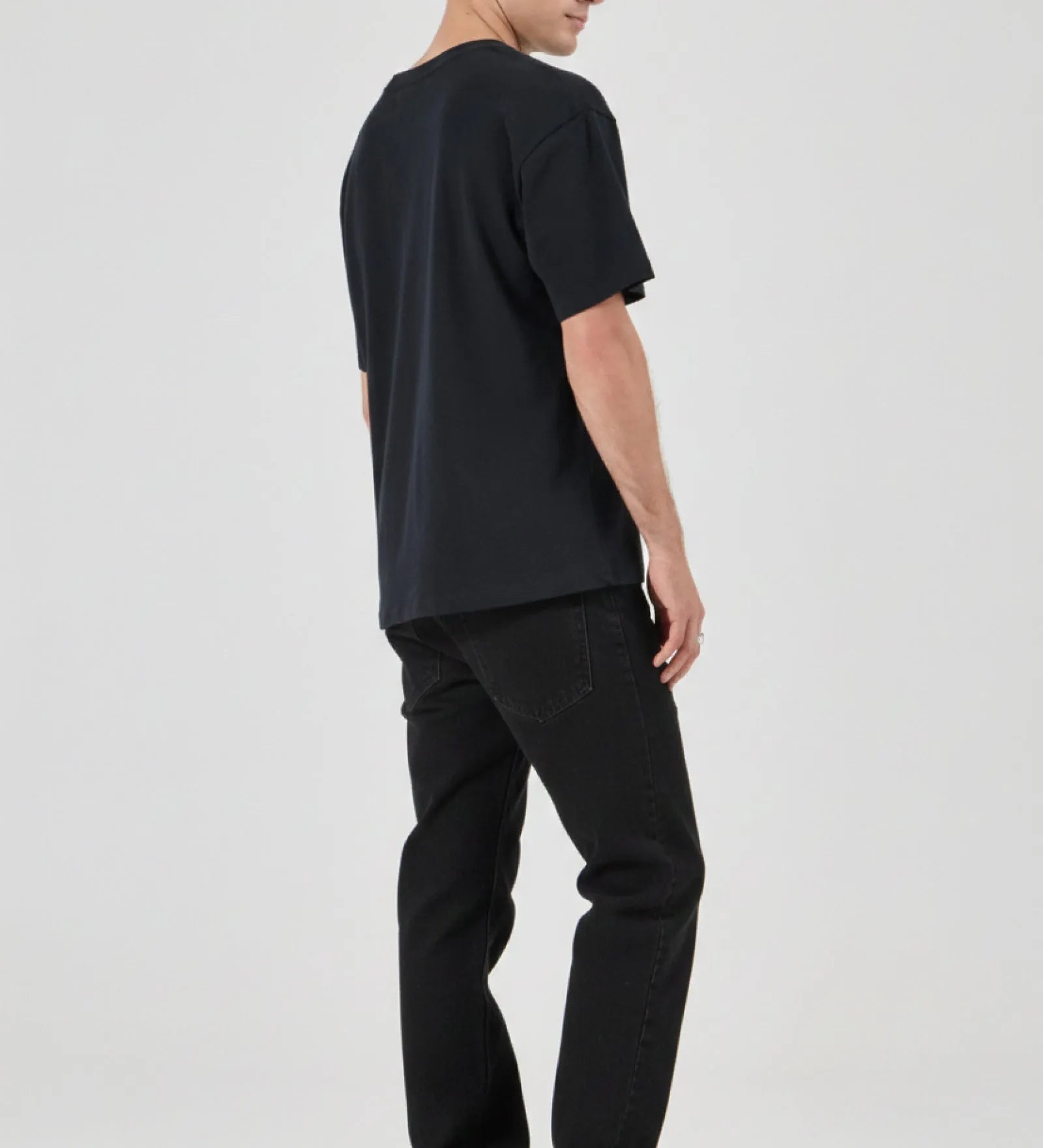 Person wearing a black t-shirt and black pants on a white background