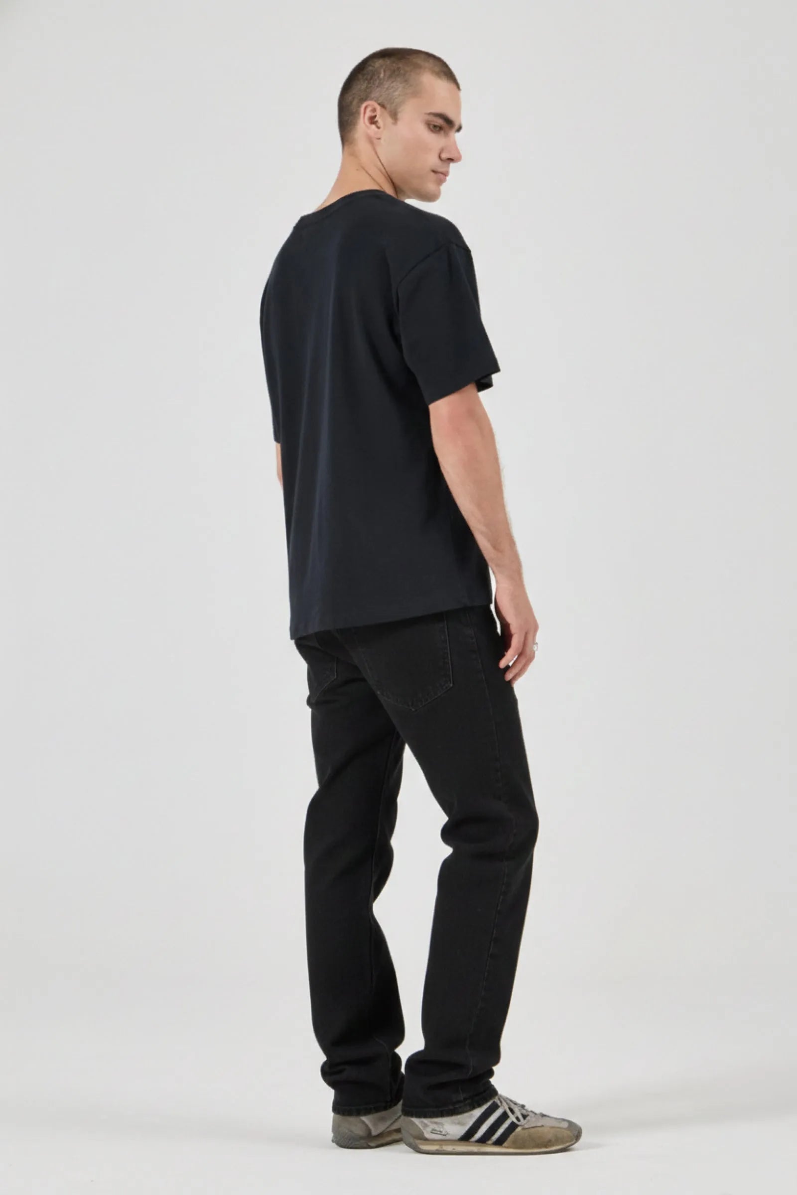Person wearing a black t-shirt and black pants on a white background