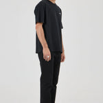 Man wearing a black t-shirt and pants on a white background