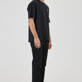 Man wearing a black t-shirt and pants on a white background