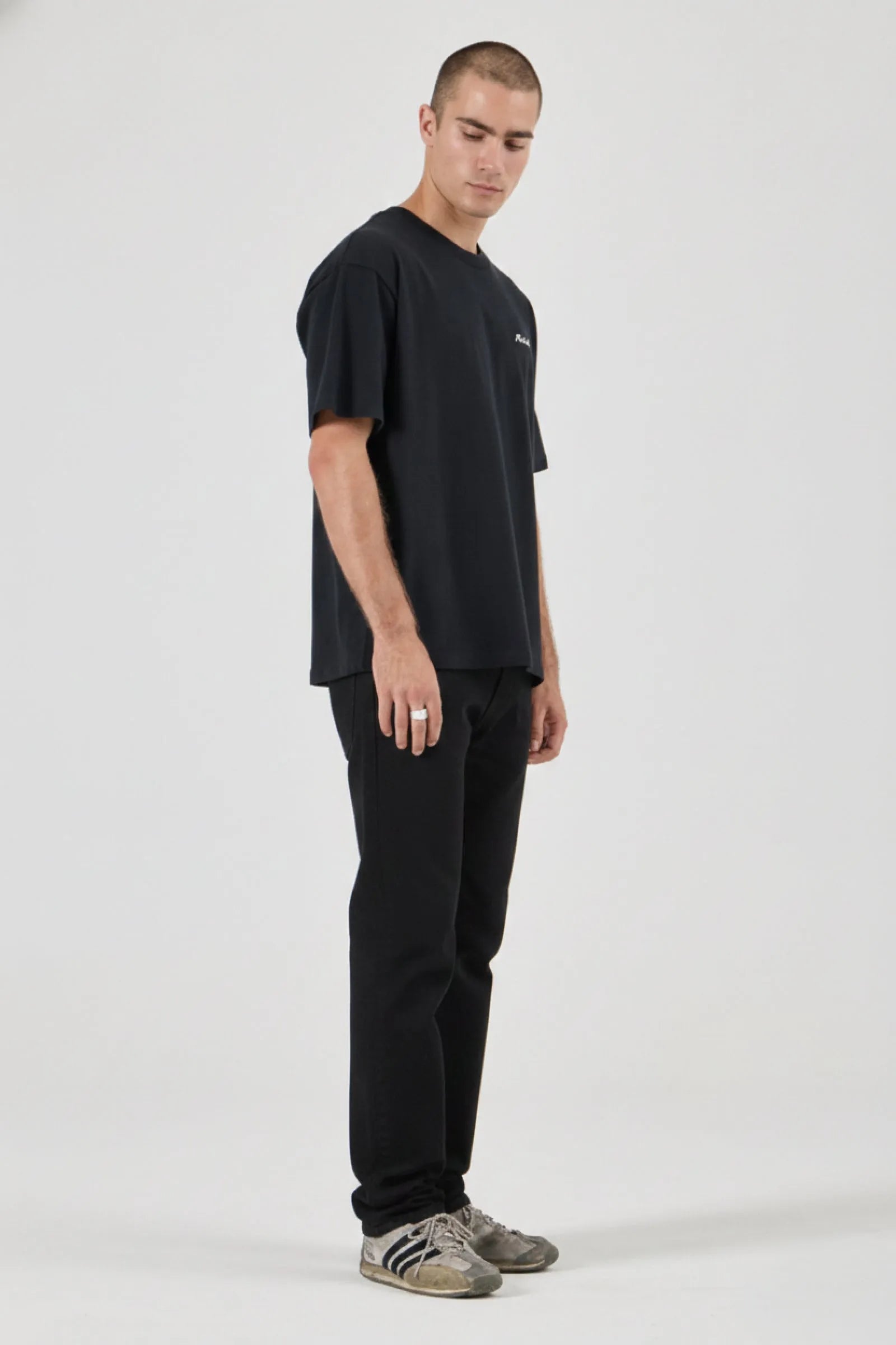 Man wearing a black t-shirt and pants on a white background