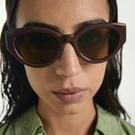 Woman wearing brown sunglasses with a blurred background