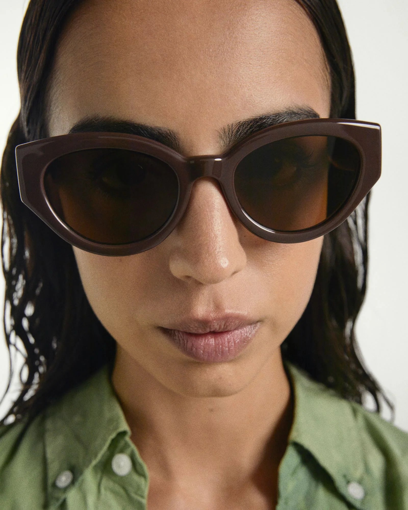Woman wearing brown sunglasses with a blurred background