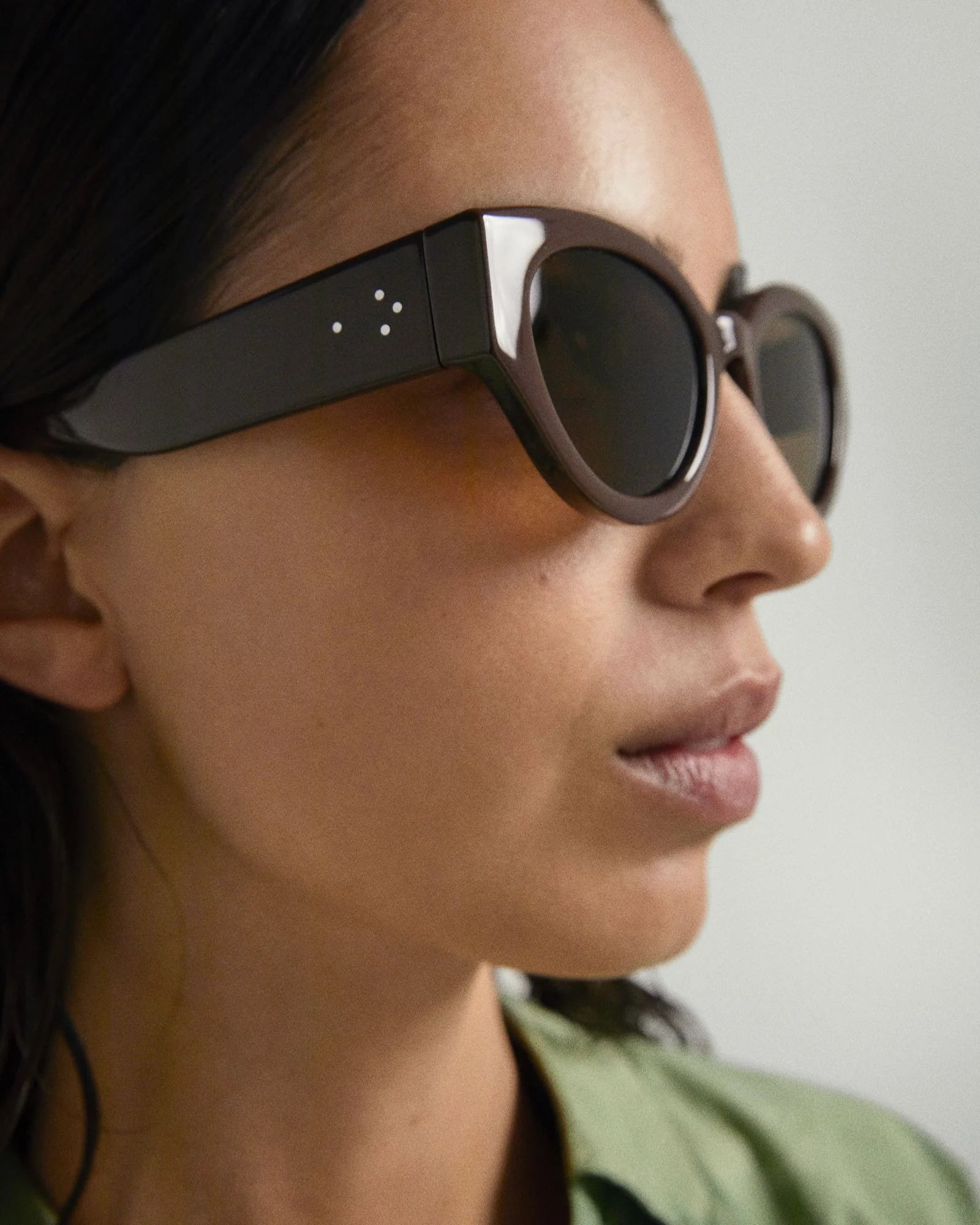 Person wearing a pair of sunglasses with a blurred background