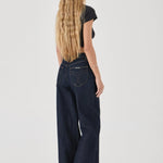 Person wearing dark blue jeans on a white background