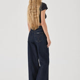 Person wearing dark blue jeans on a white background