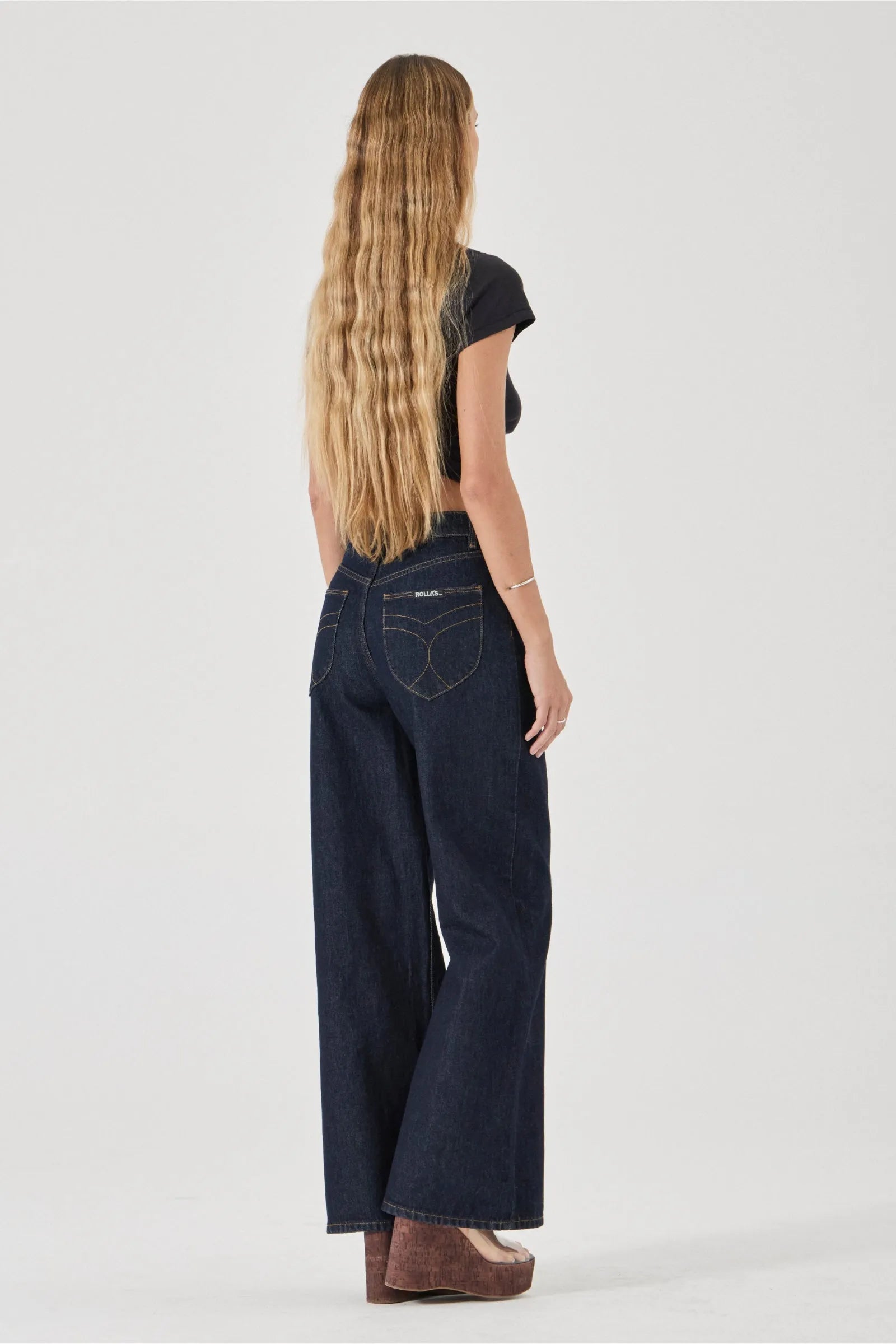 Person wearing dark blue jeans on a white background