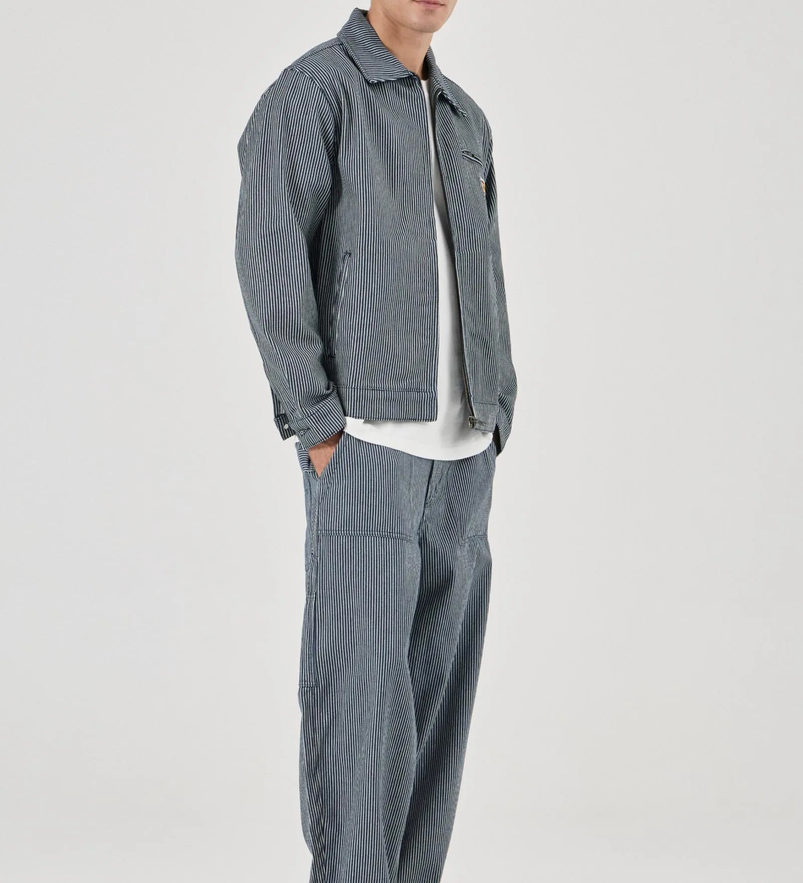 Man wearing a gray jacket and pants on a white background