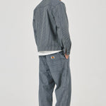 Person wearing a gray checkered jacket and pants on a white background